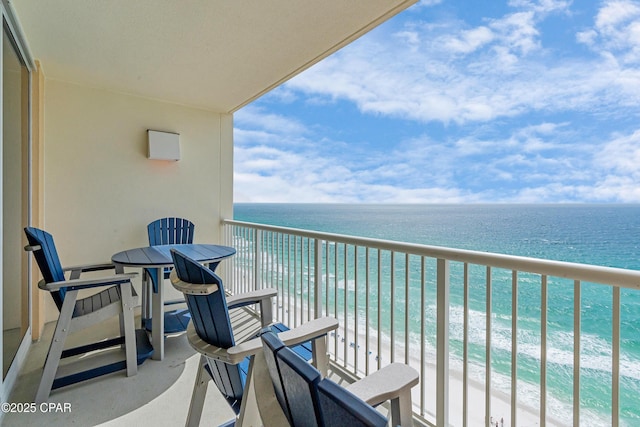 balcony featuring a beach view and a water view