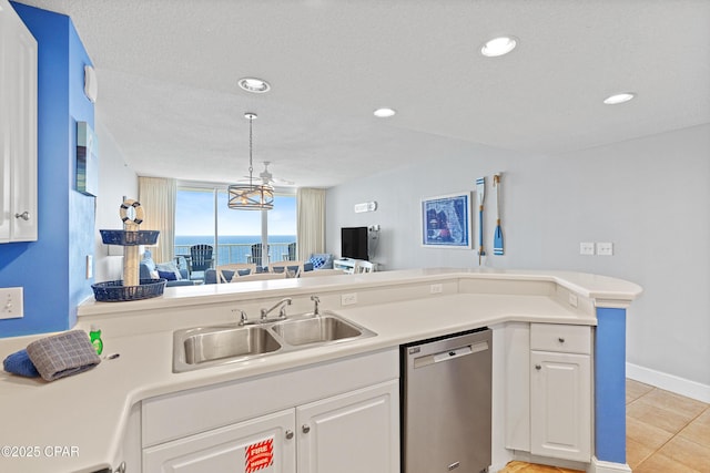 kitchen with a sink, stainless steel dishwasher, and light countertops