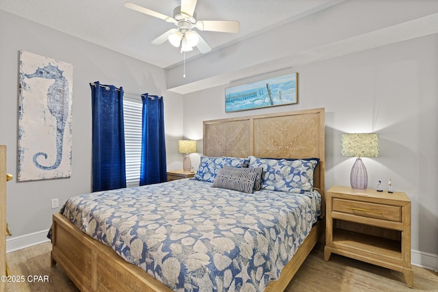 bedroom with a ceiling fan, wood finished floors, and baseboards