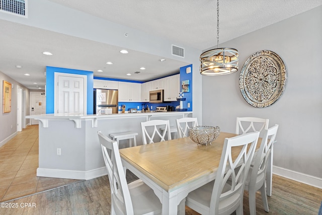 dining room featuring visible vents, recessed lighting, a textured ceiling, and baseboards