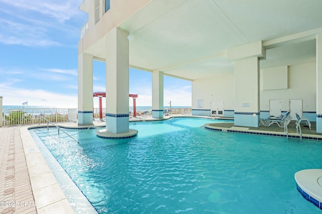 community pool with a patio area and fence