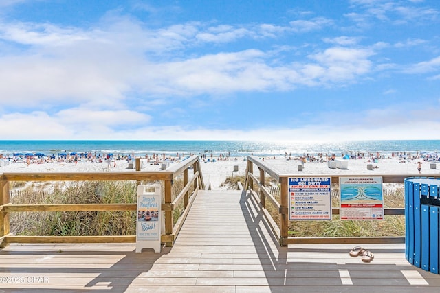 view of property's community featuring a beach view and a water view