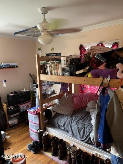 bedroom with hardwood / wood-style floors and ornamental molding