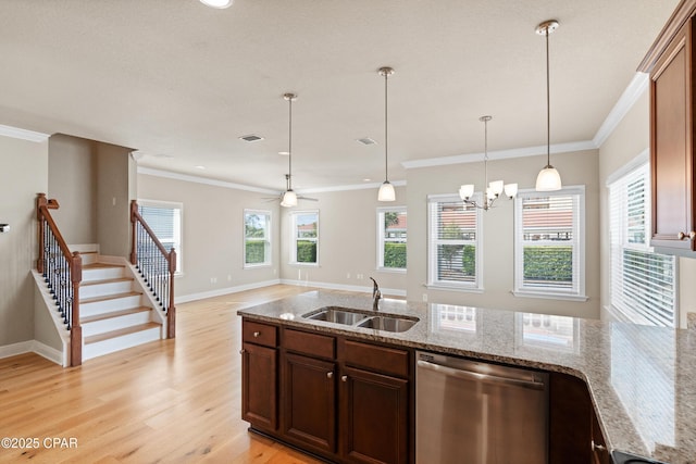 kitchen featuring light wood-type flooring, light stone countertops, dishwasher, a sink, and hanging light fixtures