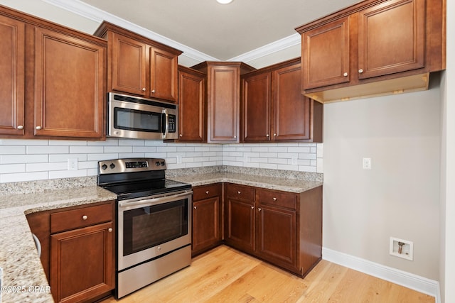 kitchen featuring crown molding, light stone countertops, light wood-type flooring, stainless steel appliances, and backsplash