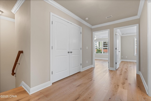foyer featuring crown molding, visible vents, baseboards, and light wood-type flooring