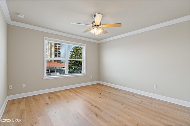 spare room featuring light wood-style floors, baseboards, crown molding, and a ceiling fan