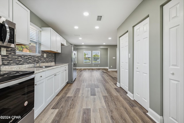 kitchen featuring white cabinets, visible vents, stainless steel appliances, and a sink