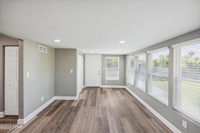 interior space with recessed lighting, wood finished floors, visible vents, and baseboards