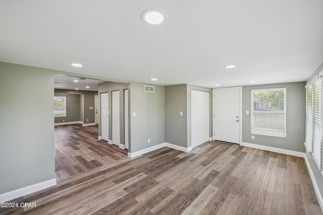 empty room with baseboards, visible vents, and wood finished floors