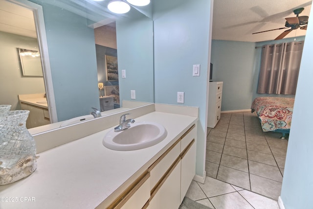 bathroom featuring tile patterned flooring, ceiling fan, vanity, and baseboards