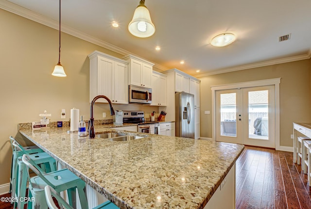 kitchen featuring pendant lighting, white cabinetry, kitchen peninsula, stainless steel appliances, and french doors