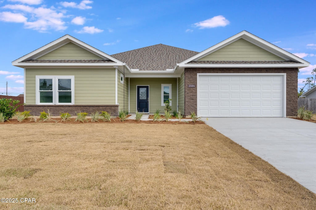 view of front of property featuring a garage and a front lawn