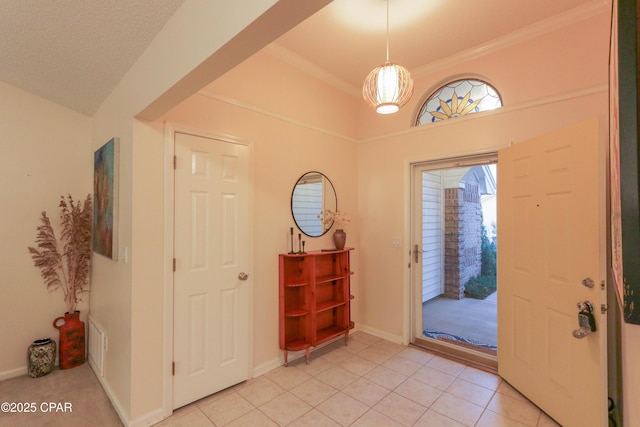 foyer featuring crown molding, light tile patterned flooring, and baseboards