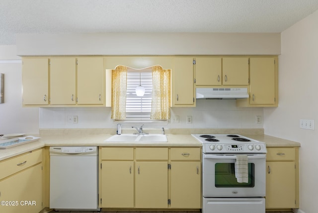 kitchen with backsplash, under cabinet range hood, white appliances, a textured ceiling, and a sink