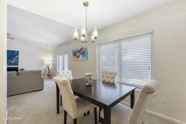 dining room featuring baseboards, light carpet, a notable chandelier, and vaulted ceiling