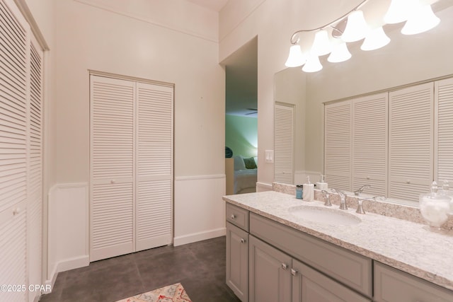 bathroom with vanity, a closet, and wainscoting