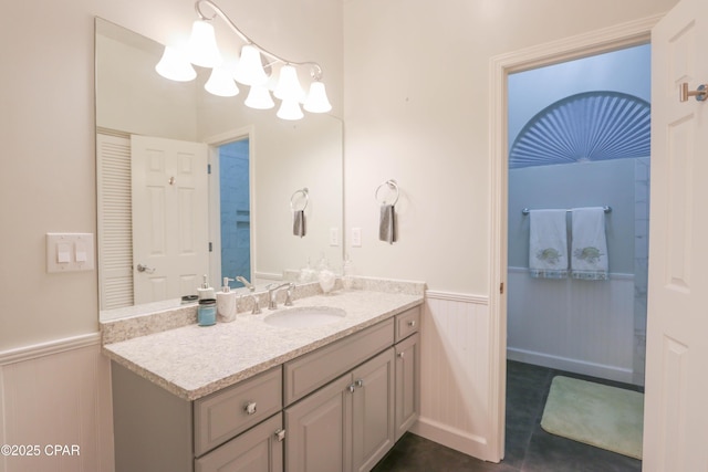 bathroom featuring a wainscoted wall, a chandelier, and vanity