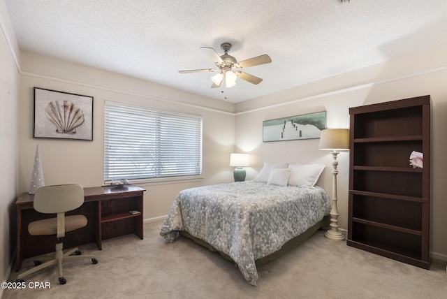 bedroom with a ceiling fan, a textured ceiling, and carpet flooring