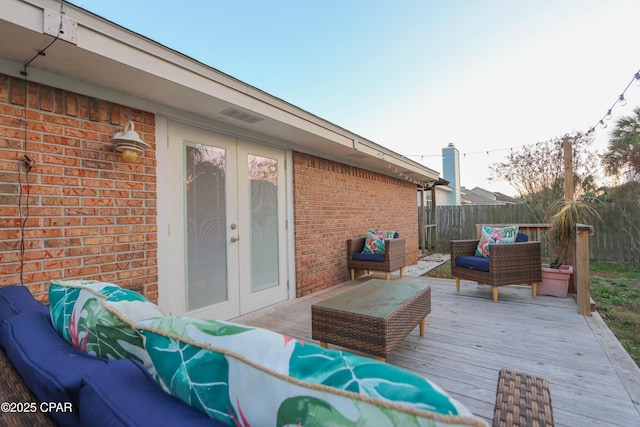 wooden terrace featuring french doors, an outdoor hangout area, and fence