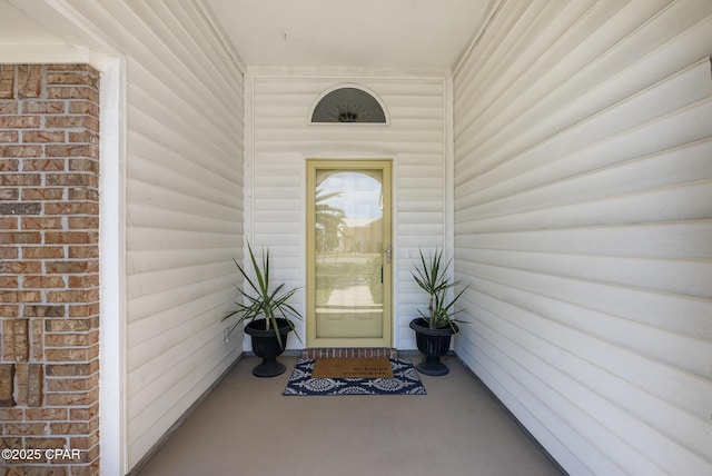 view of exterior entry featuring brick siding