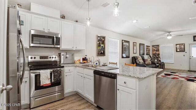 kitchen with white cabinetry, stainless steel appliances, and kitchen peninsula