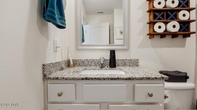 bathroom featuring vanity and toilet