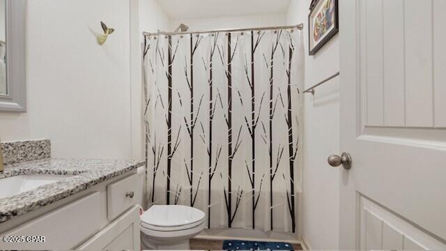 full bathroom featuring toilet, vanity, and shower / bathtub combination with curtain