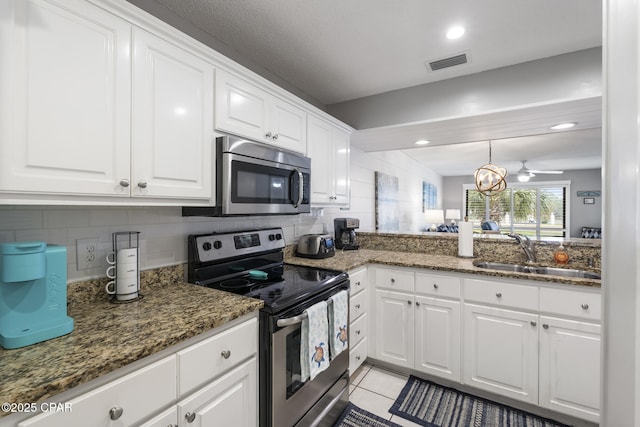 kitchen with sink, white cabinetry, backsplash, stainless steel appliances, and dark stone counters