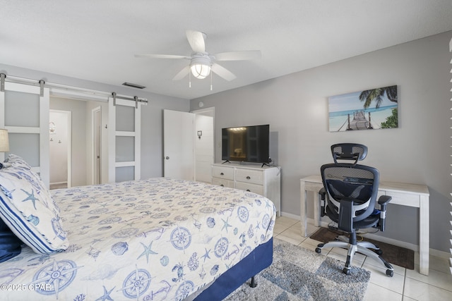 bedroom with a barn door, light tile patterned floors, and ceiling fan