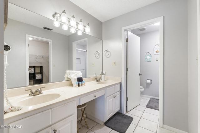 bathroom featuring vanity, tile patterned floors, and toilet