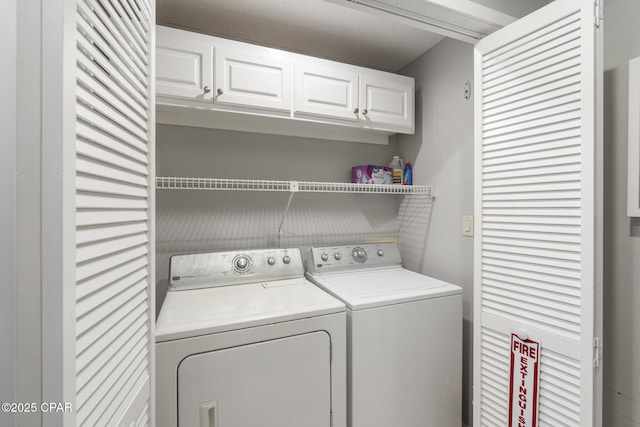 laundry area with cabinets and washer and clothes dryer