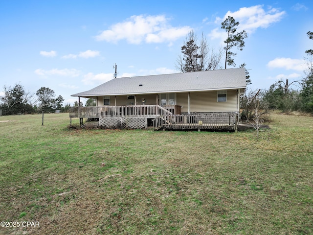 rear view of house featuring a wooden deck and a yard