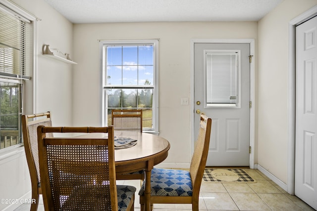 dining space featuring light tile patterned floors and a textured ceiling