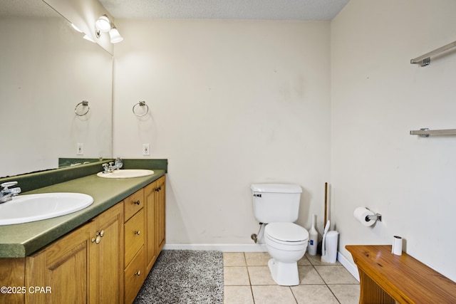 bathroom with vanity, toilet, tile patterned flooring, and a textured ceiling