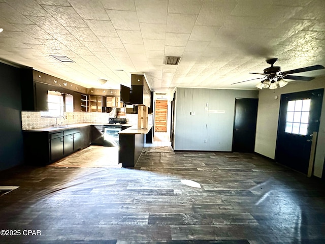 kitchen featuring electric stove, dark hardwood / wood-style flooring, a breakfast bar, and tasteful backsplash