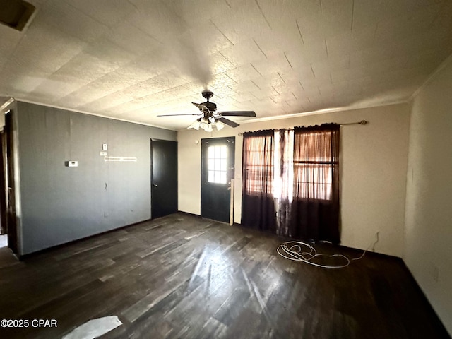 interior space with ceiling fan, ornamental molding, and dark hardwood / wood-style floors