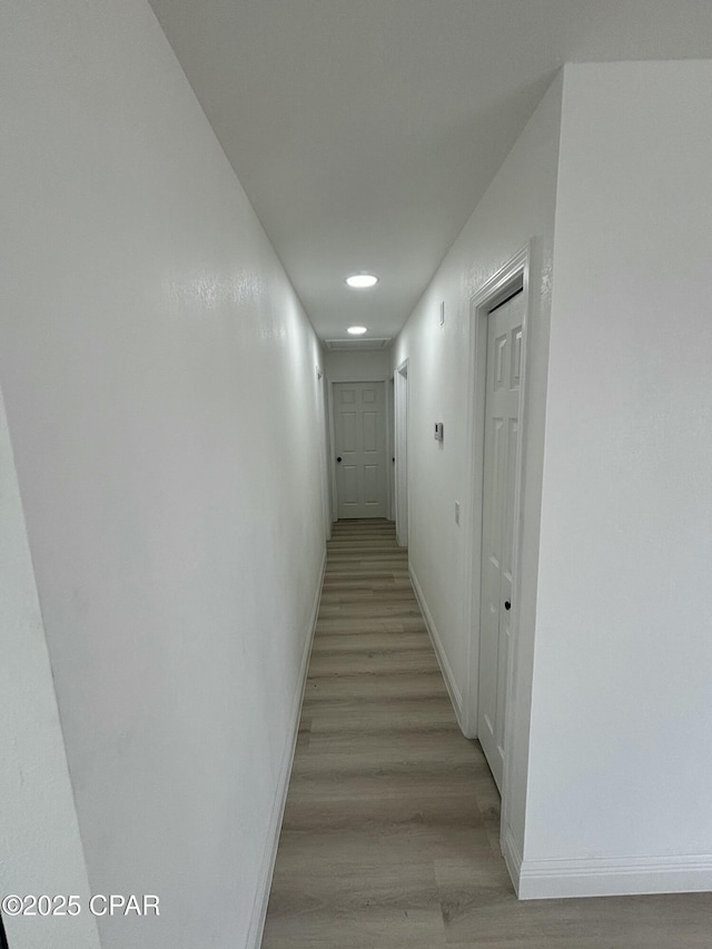 hallway with light hardwood / wood-style floors