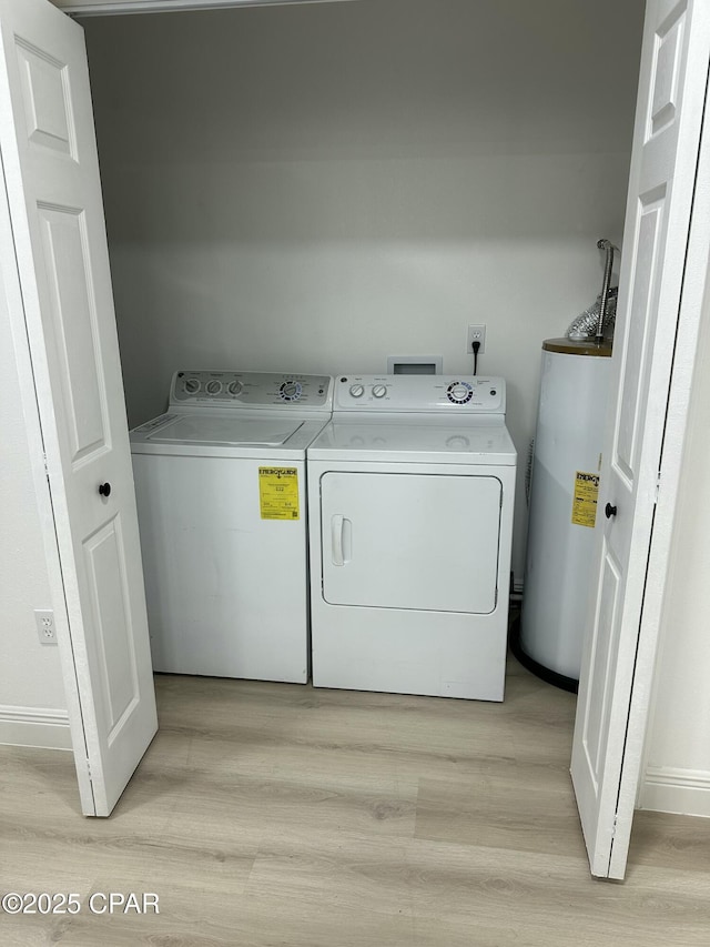 laundry room featuring light wood-type flooring, washing machine and clothes dryer, and gas water heater