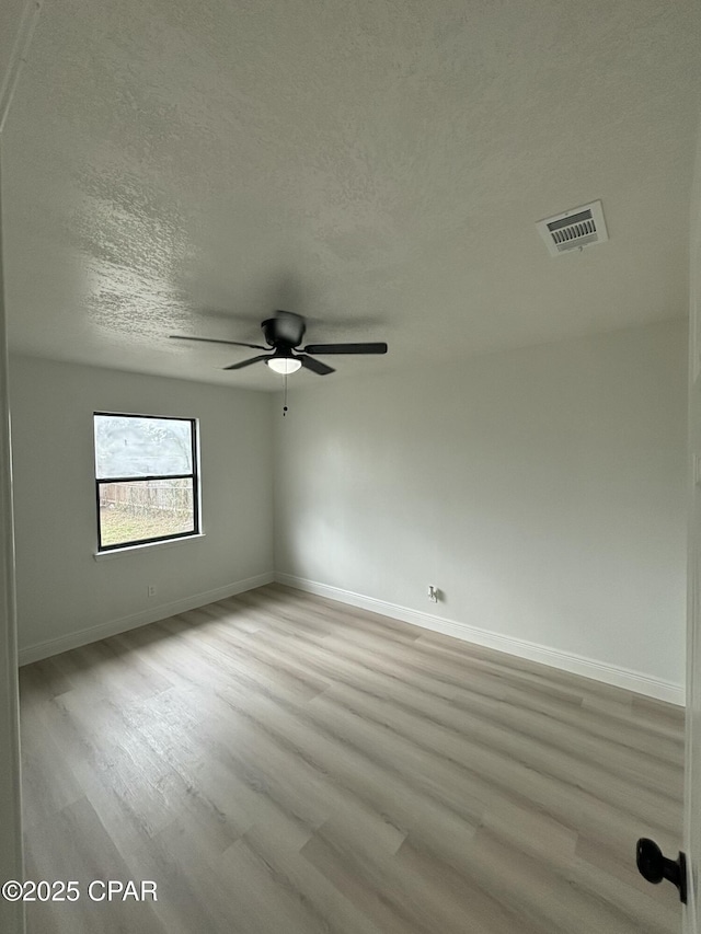 unfurnished room with a textured ceiling, ceiling fan, and light hardwood / wood-style flooring