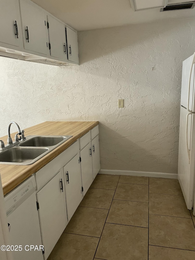 kitchen featuring light countertops, white appliances, a sink, and white cabinets