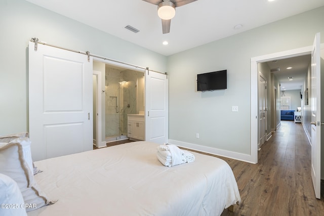 bedroom featuring wood finished floors, visible vents, baseboards, recessed lighting, and a barn door