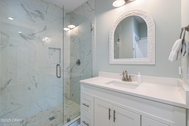 full bathroom with a marble finish shower and vanity
