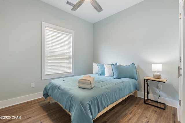 bedroom with ceiling fan, visible vents, baseboards, and wood finished floors