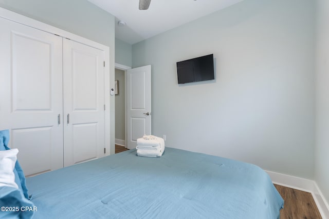 bedroom featuring a closet, baseboards, dark wood-type flooring, and a ceiling fan