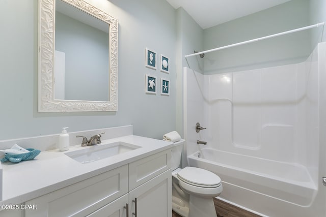 full bath with washtub / shower combination, toilet, wood finished floors, and vanity