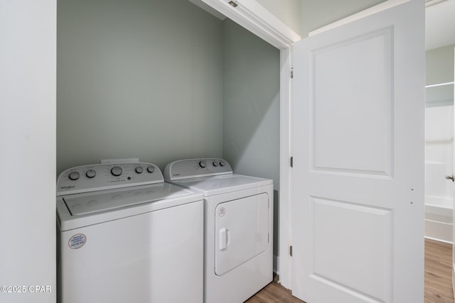 clothes washing area featuring laundry area, independent washer and dryer, and light wood-type flooring