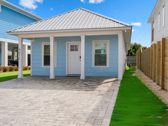view of front facade with metal roof and fence