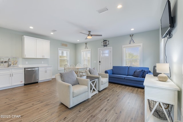 living room with light wood-style flooring, recessed lighting, a ceiling fan, and visible vents
