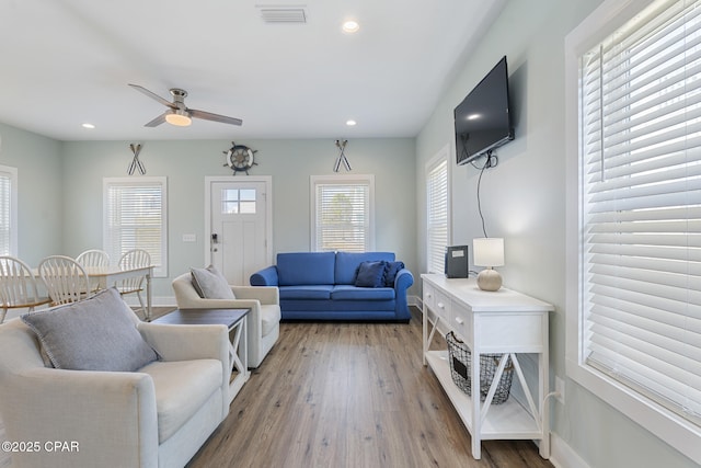 living room featuring visible vents, baseboards, ceiling fan, recessed lighting, and wood finished floors